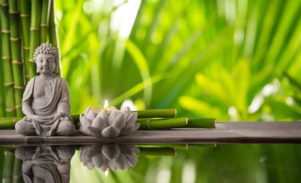 Buddha in meditation with burning candle